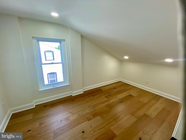 additional living space featuring lofted ceiling and hardwood / wood-style flooring