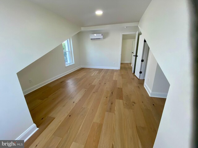 bonus room featuring light hardwood / wood-style floors and a wall unit AC