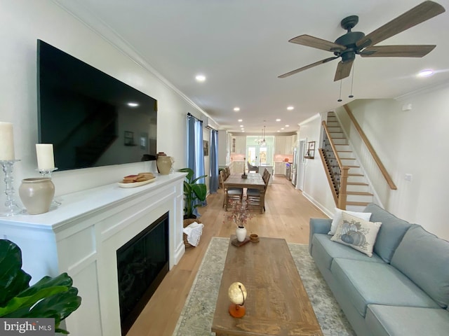 living room with ceiling fan, light hardwood / wood-style flooring, and ornamental molding