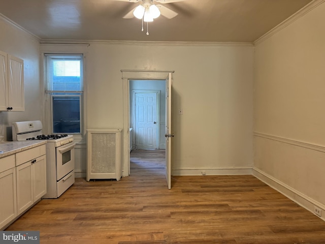 kitchen featuring ceiling fan, white cabinets, white gas range, crown molding, and light hardwood / wood-style floors