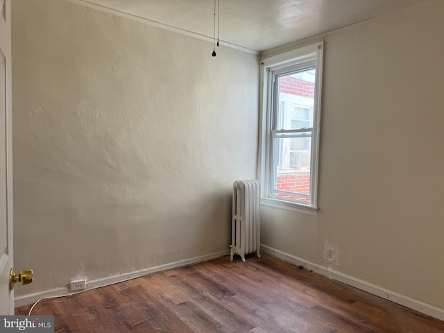 empty room with radiator and hardwood / wood-style flooring