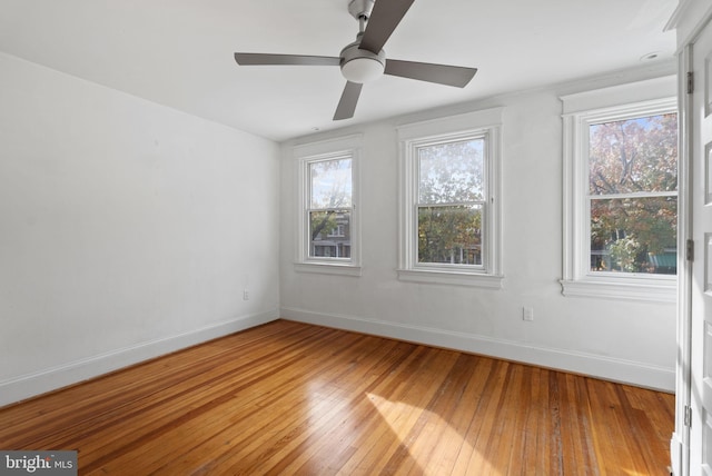 empty room with plenty of natural light, hardwood / wood-style flooring, and ceiling fan