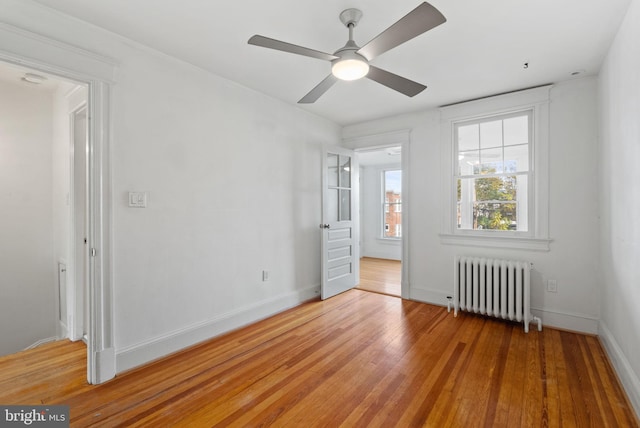 unfurnished bedroom featuring radiator heating unit, wood-type flooring, and ceiling fan