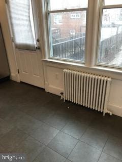 doorway with radiator, tile patterned flooring, and plenty of natural light