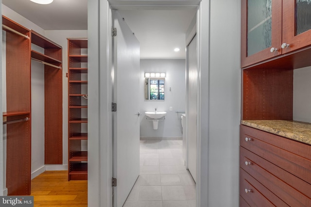 walk in closet with light hardwood / wood-style floors