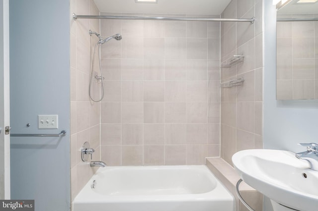 bathroom with sink and tiled shower / bath