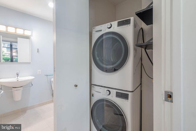 washroom with stacked washer and clothes dryer and light tile patterned flooring