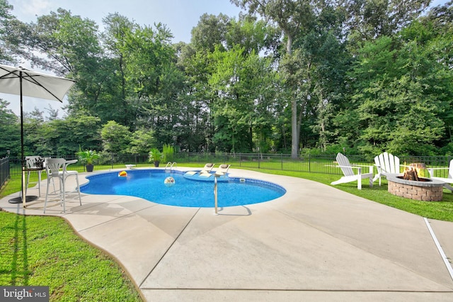 view of swimming pool featuring a yard, an outdoor fire pit, and a patio area