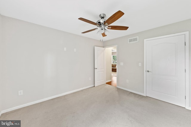 unfurnished bedroom with ceiling fan and light colored carpet