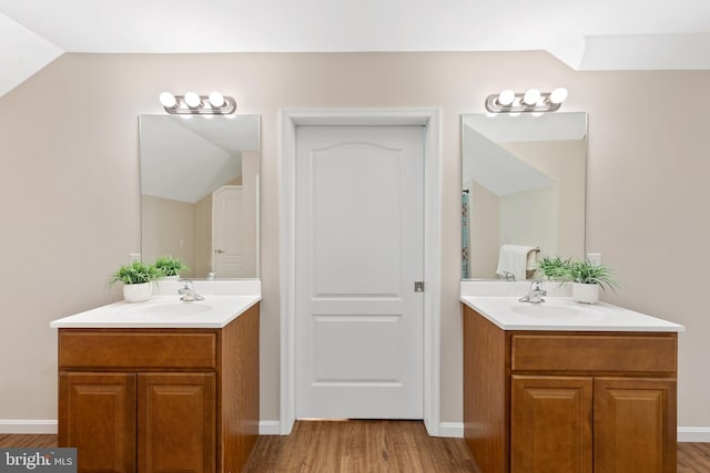 bathroom featuring vanity, vaulted ceiling, and hardwood / wood-style flooring