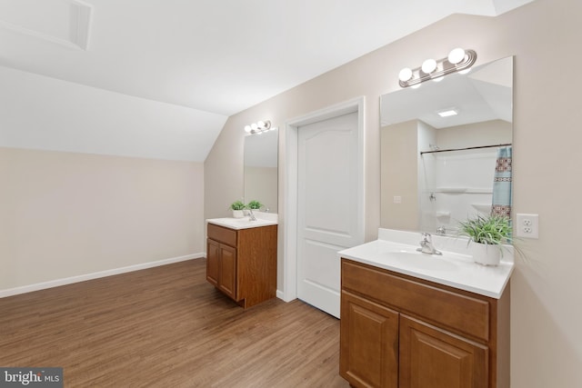 bathroom featuring lofted ceiling, hardwood / wood-style flooring, vanity, and curtained shower