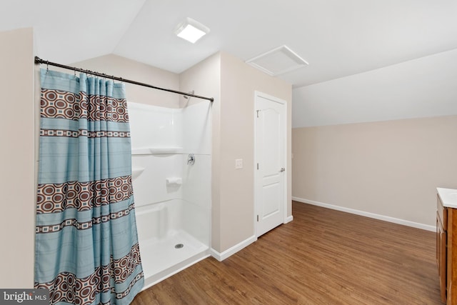 bathroom featuring hardwood / wood-style floors, lofted ceiling, vanity, and curtained shower