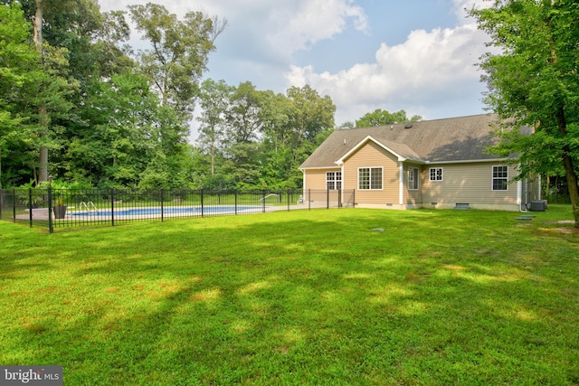 view of yard with central AC and a fenced in pool