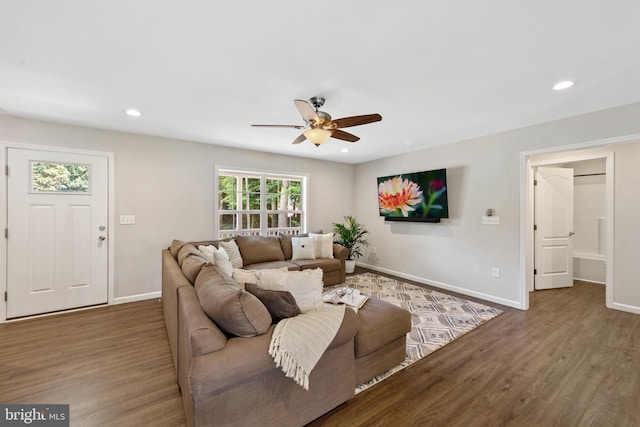 living room with ceiling fan and dark wood-type flooring