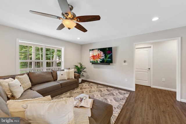 living room featuring ceiling fan and dark hardwood / wood-style floors