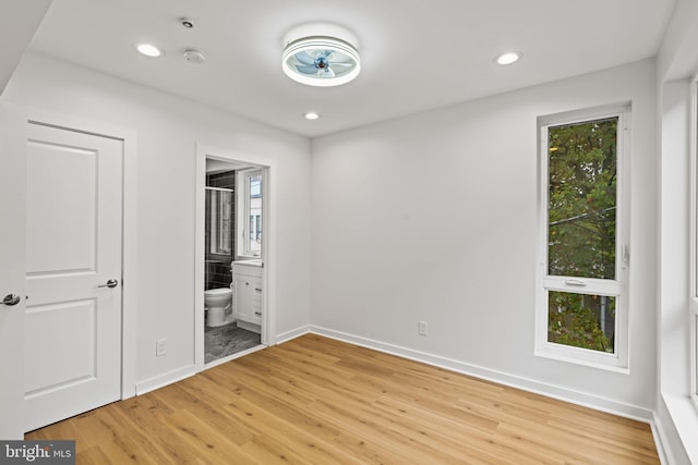 unfurnished bedroom featuring hardwood / wood-style flooring and ensuite bath