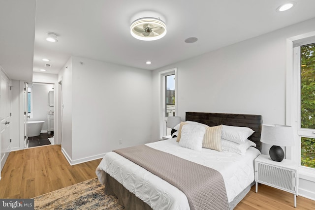 bedroom with light hardwood / wood-style floors and connected bathroom