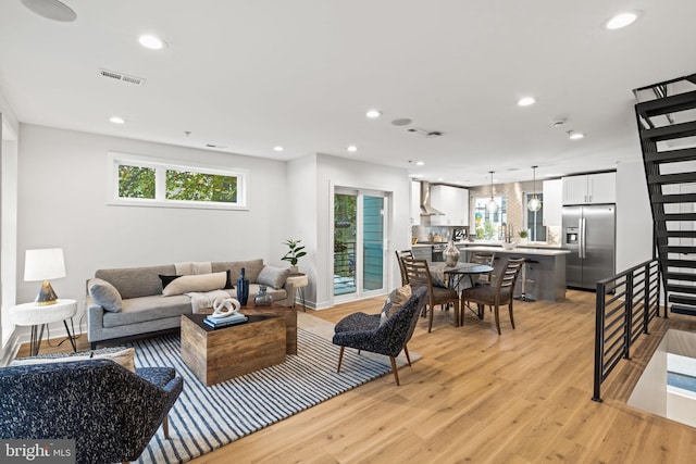 living room with light hardwood / wood-style flooring and sink