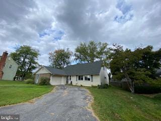 view of front of property featuring a garage and a front lawn