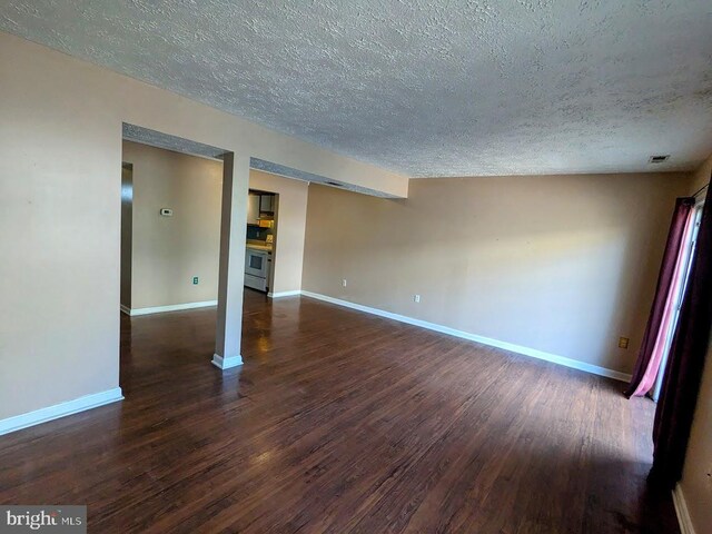 empty room featuring a textured ceiling and dark hardwood / wood-style flooring