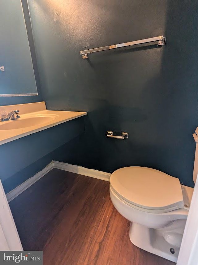 bathroom featuring wood-type flooring, sink, and toilet