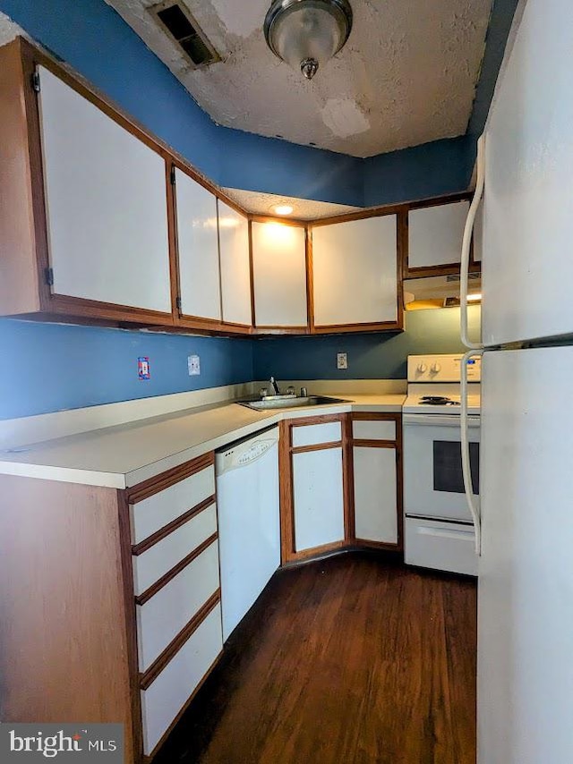 kitchen with white cabinets, white appliances, sink, and dark hardwood / wood-style flooring