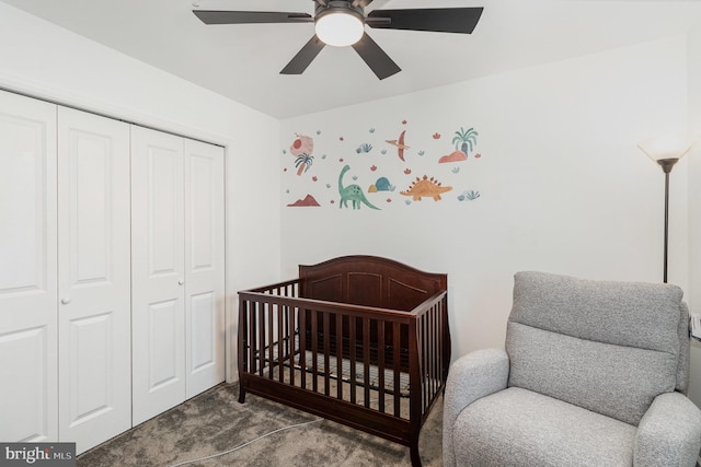 bedroom with carpet flooring, ceiling fan, a nursery area, and a closet