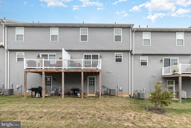 rear view of house with a patio, a yard, and central AC unit