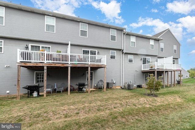 back of property with central AC unit, a deck, and a yard