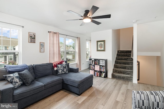 living room with light wood-type flooring and ceiling fan