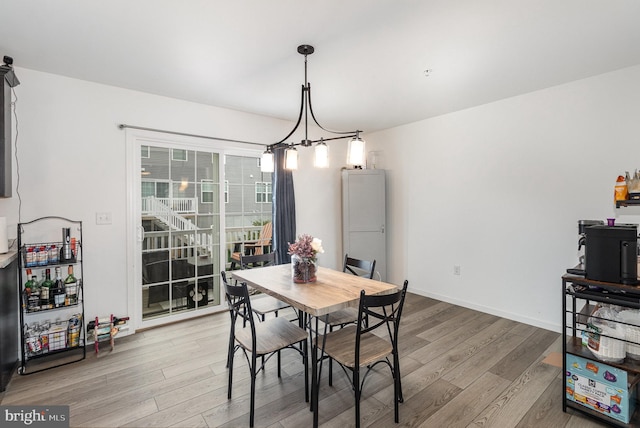 dining area featuring an inviting chandelier and light hardwood / wood-style floors