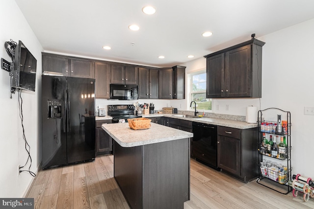 kitchen with light wood-type flooring, black appliances, dark brown cabinets, and sink