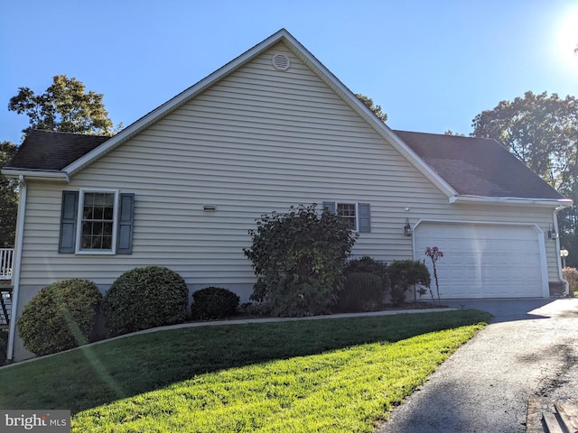 view of home's exterior with a lawn and a garage