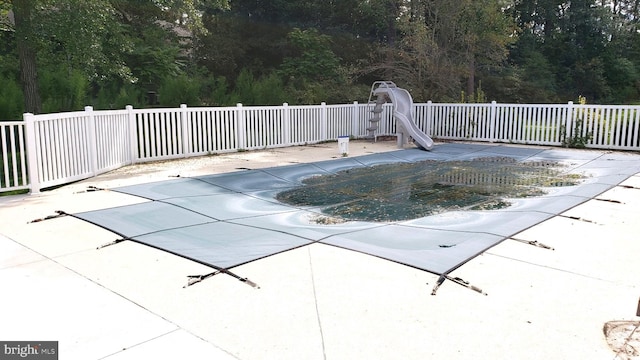 view of pool featuring a water slide and a patio area