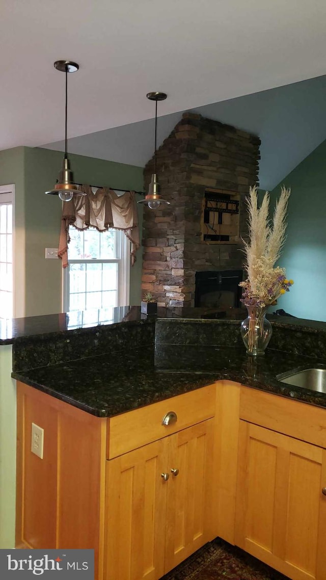 kitchen with decorative light fixtures and dark stone counters