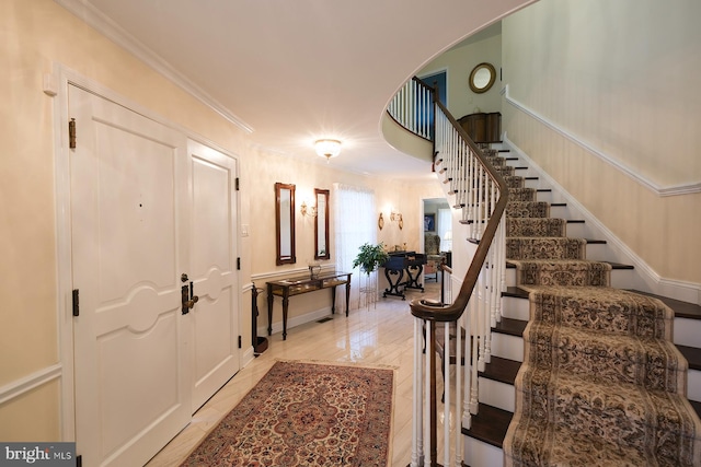 tiled foyer entrance featuring crown molding