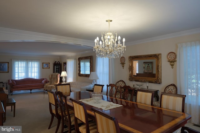 dining room featuring carpet floors, crown molding, and a notable chandelier