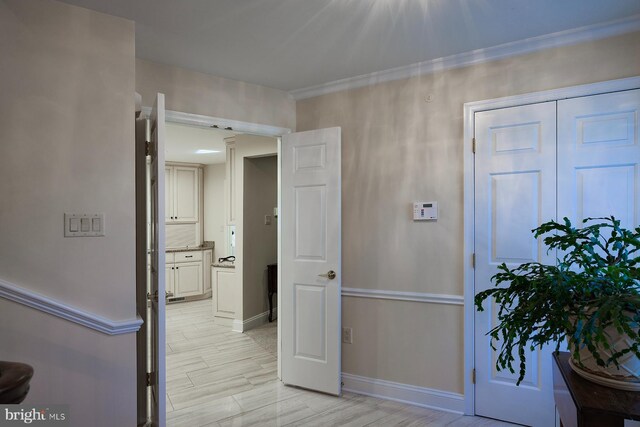 hall featuring ornamental molding and light hardwood / wood-style floors