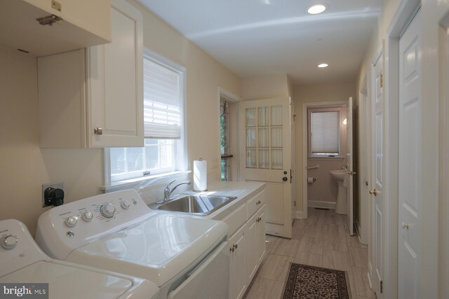 washroom with separate washer and dryer, cabinets, and sink