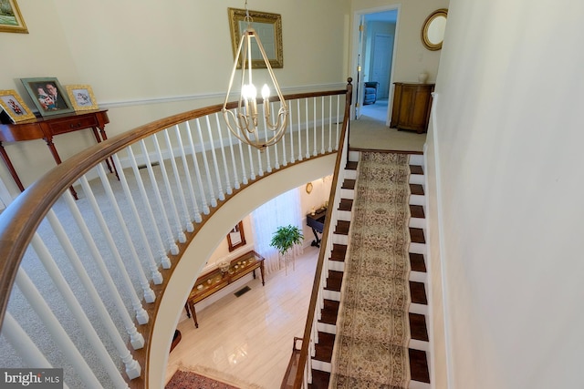 stairs featuring an inviting chandelier and hardwood / wood-style floors