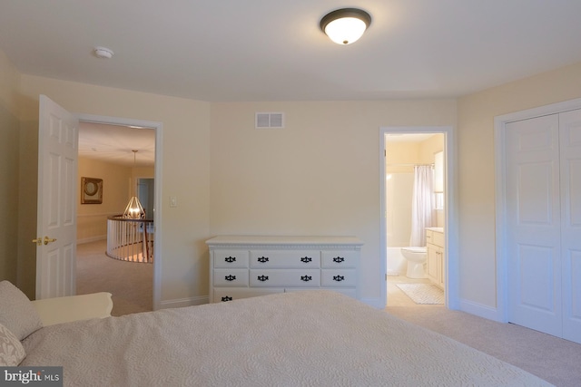 bedroom featuring carpet floors, a closet, and ensuite bath