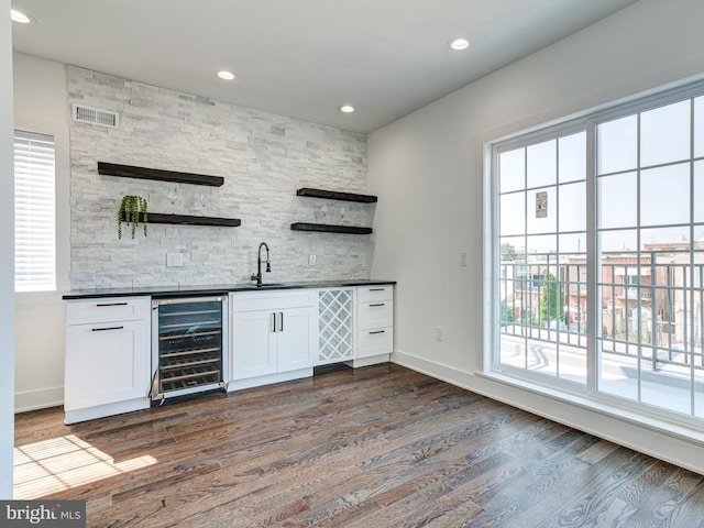 bar featuring dark hardwood / wood-style floors, white cabinetry, beverage cooler, and sink