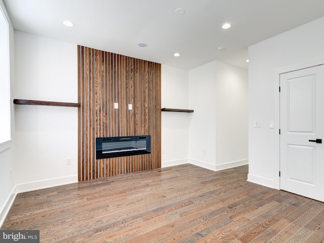 unfurnished living room with hardwood / wood-style floors and a large fireplace