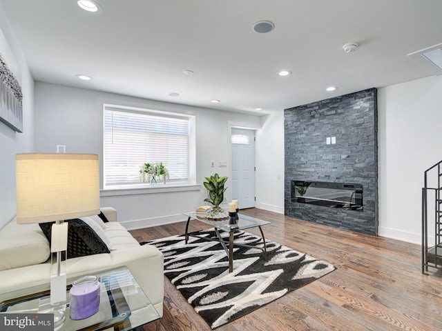 living room featuring hardwood / wood-style floors and a stone fireplace