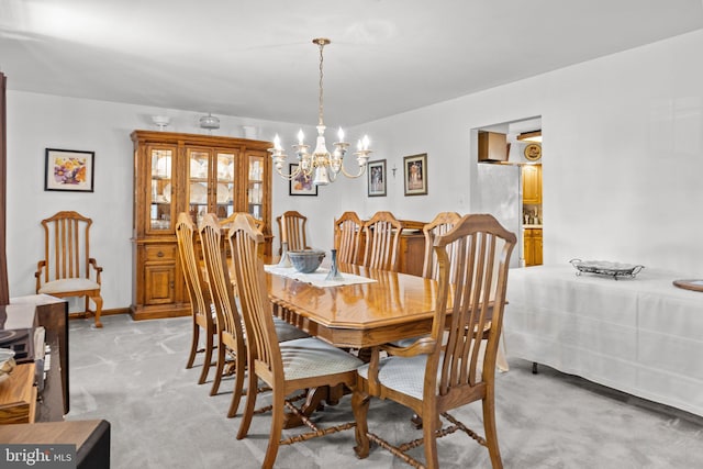 carpeted dining space featuring an inviting chandelier