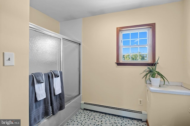 bathroom with bath / shower combo with glass door and a baseboard radiator