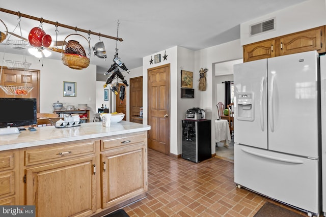 kitchen featuring ceiling fan, white refrigerator with ice dispenser, and wine cooler