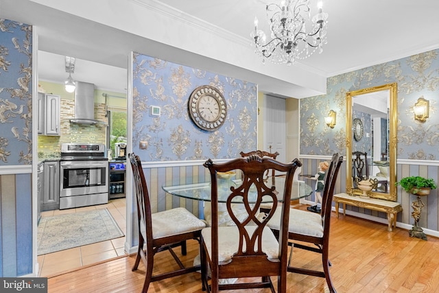 dining area with an inviting chandelier, crown molding, and light hardwood / wood-style floors