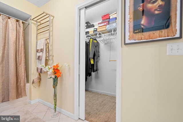 interior space featuring a shower with curtain and tile patterned flooring