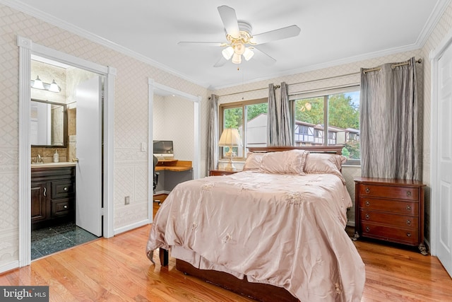 bedroom featuring crown molding, ceiling fan, ensuite bathroom, and hardwood / wood-style flooring